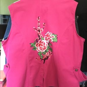 Pink vest with a large flower patch on the back.